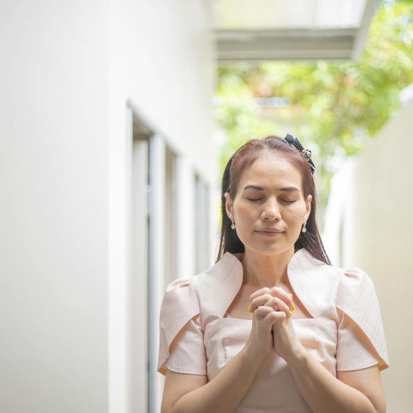 Person meditating peacefully outdoors with a calm expression.