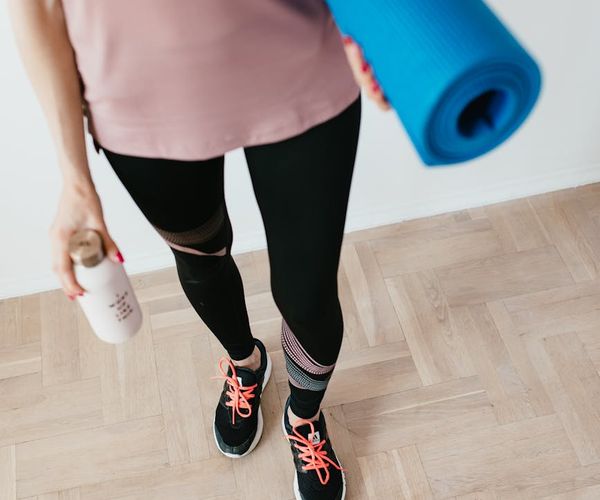 Yoga mat, water bottle and a small towel neatly arranged on the floor.